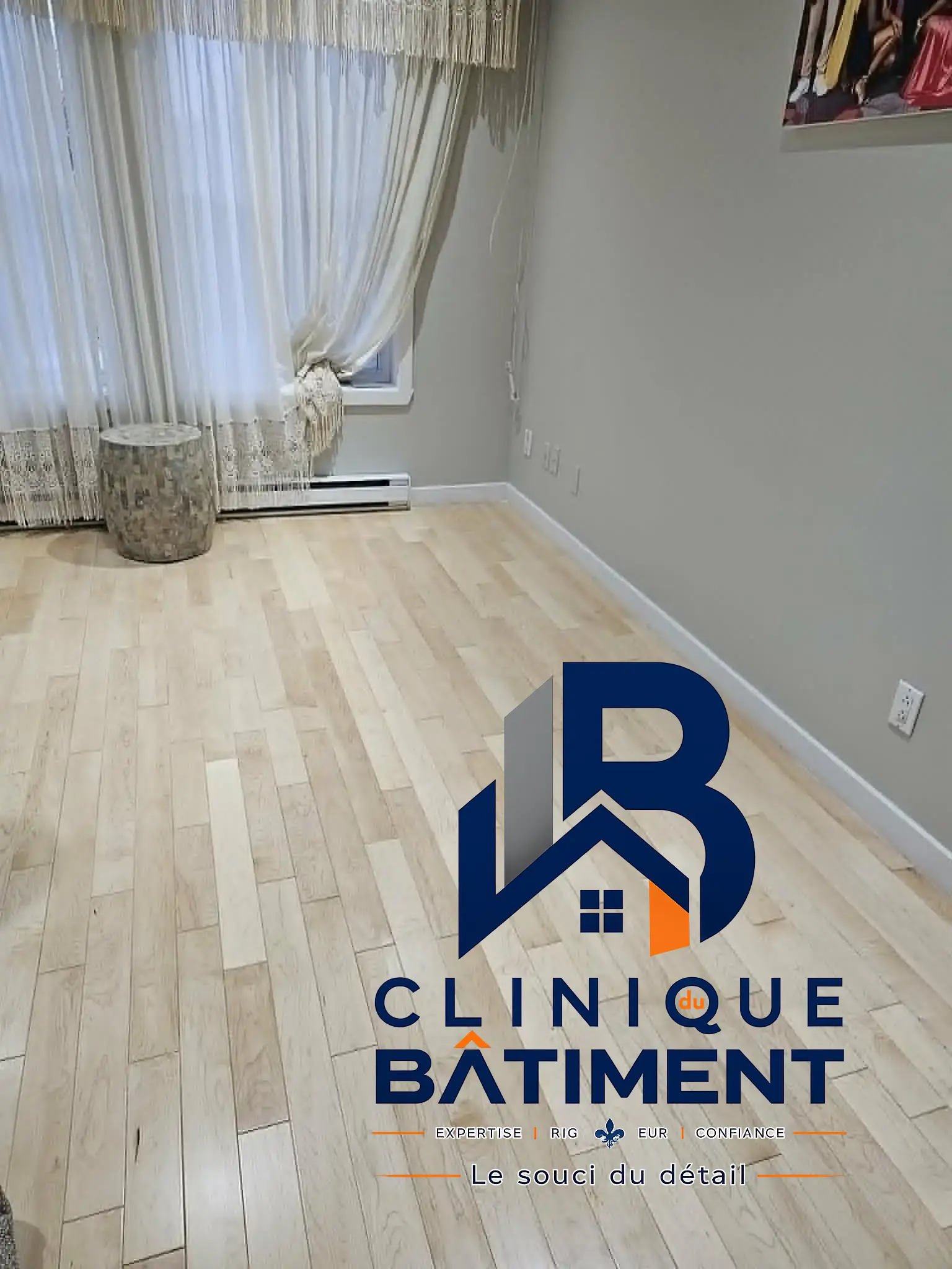 Pièce intérieure rénovée avec un parquet en bois clair et des murs gris. Réalisation intérieure à Longueuil — Clinique du Bâtiment (RBQ 5821-2606-01).