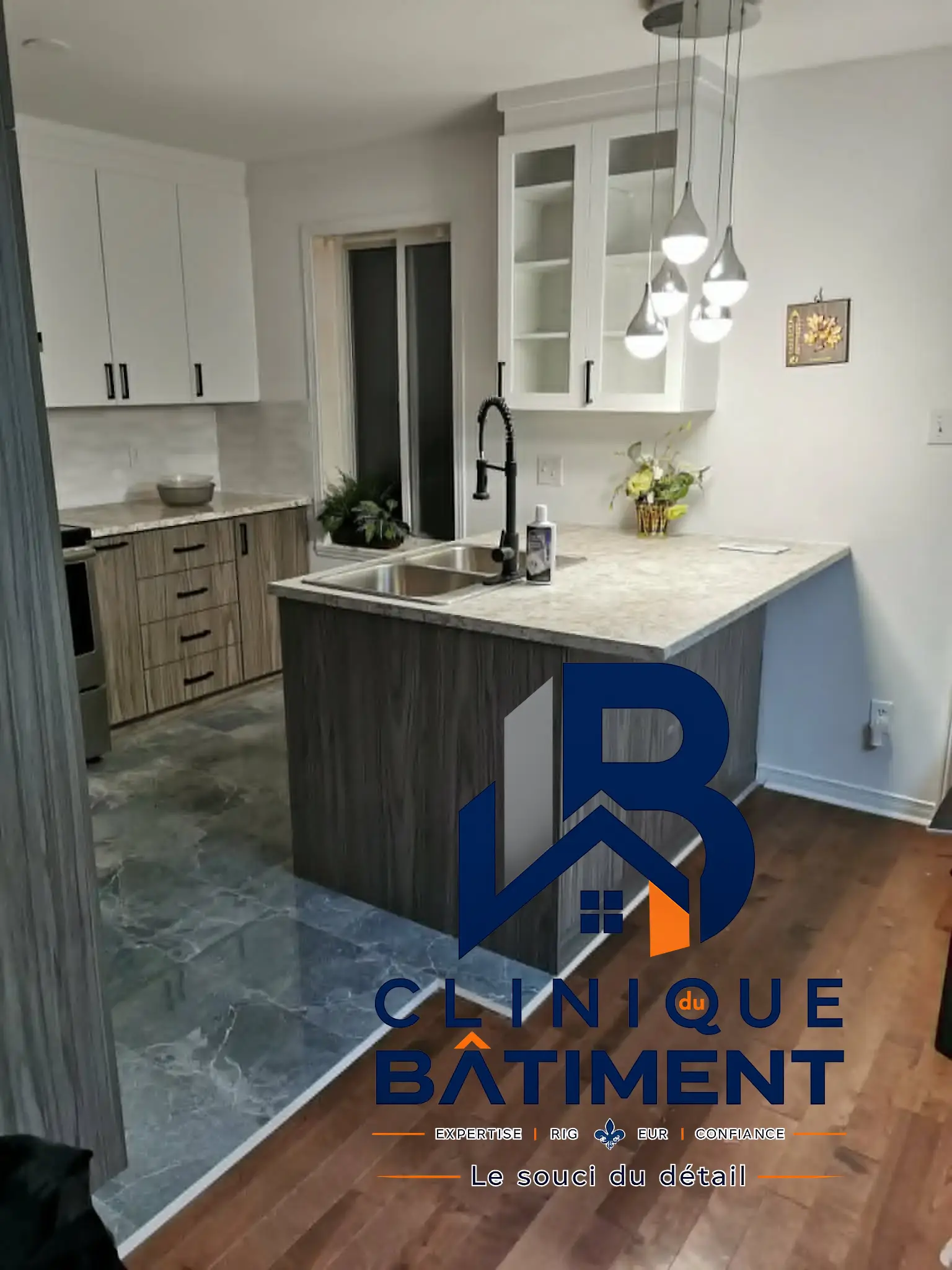 Une cuisine moderne équipée avec un îlot central, des armoires bicolores et un revêtement de sol mixte. Réalisation de cuisine sur la Rive-Sud — Clinique du Bâtiment (RBQ 5821-2606-01).