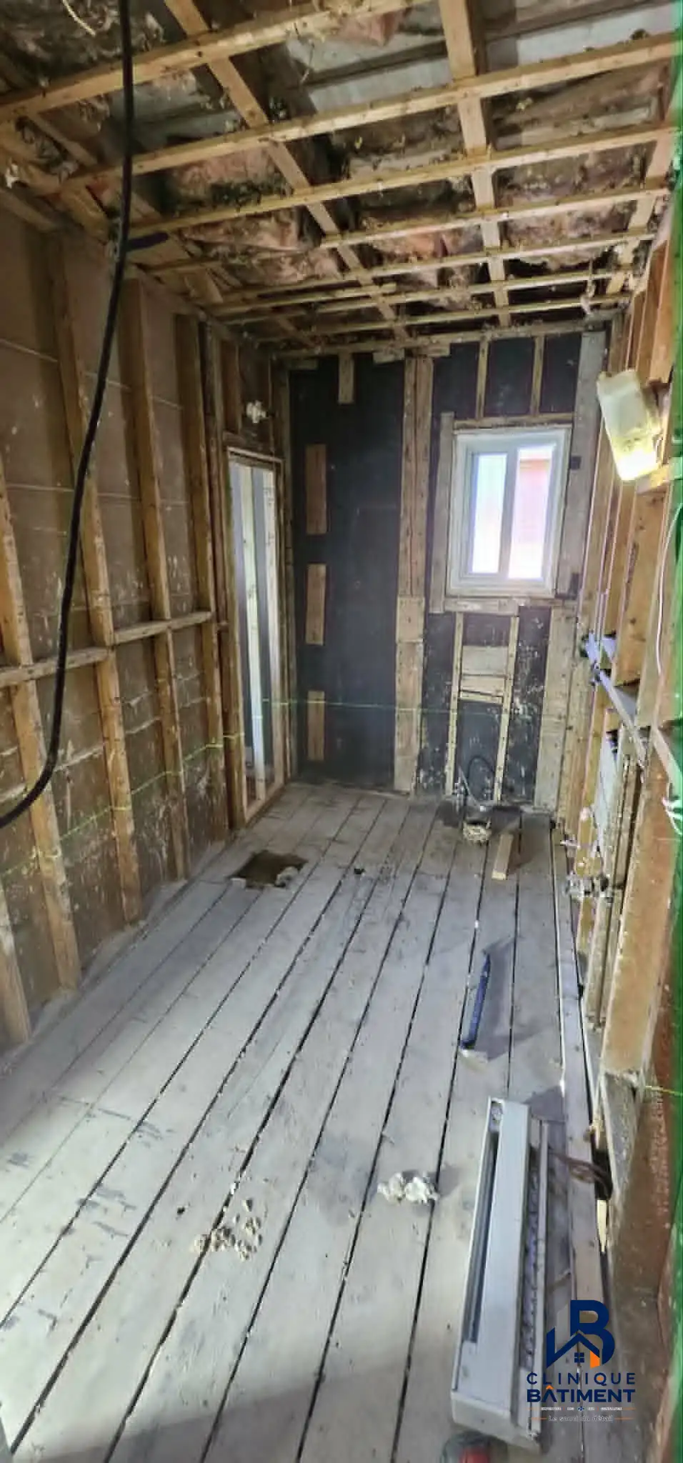 Une pièce en cours de rénovation avec des murs partiellement peints, un sous-plancher brut et des installations de plomberie et d'électricité apparentes. Chantier de cuisine à Longueuil — Clinique du Bâtiment (RBQ 5821-2606-01).