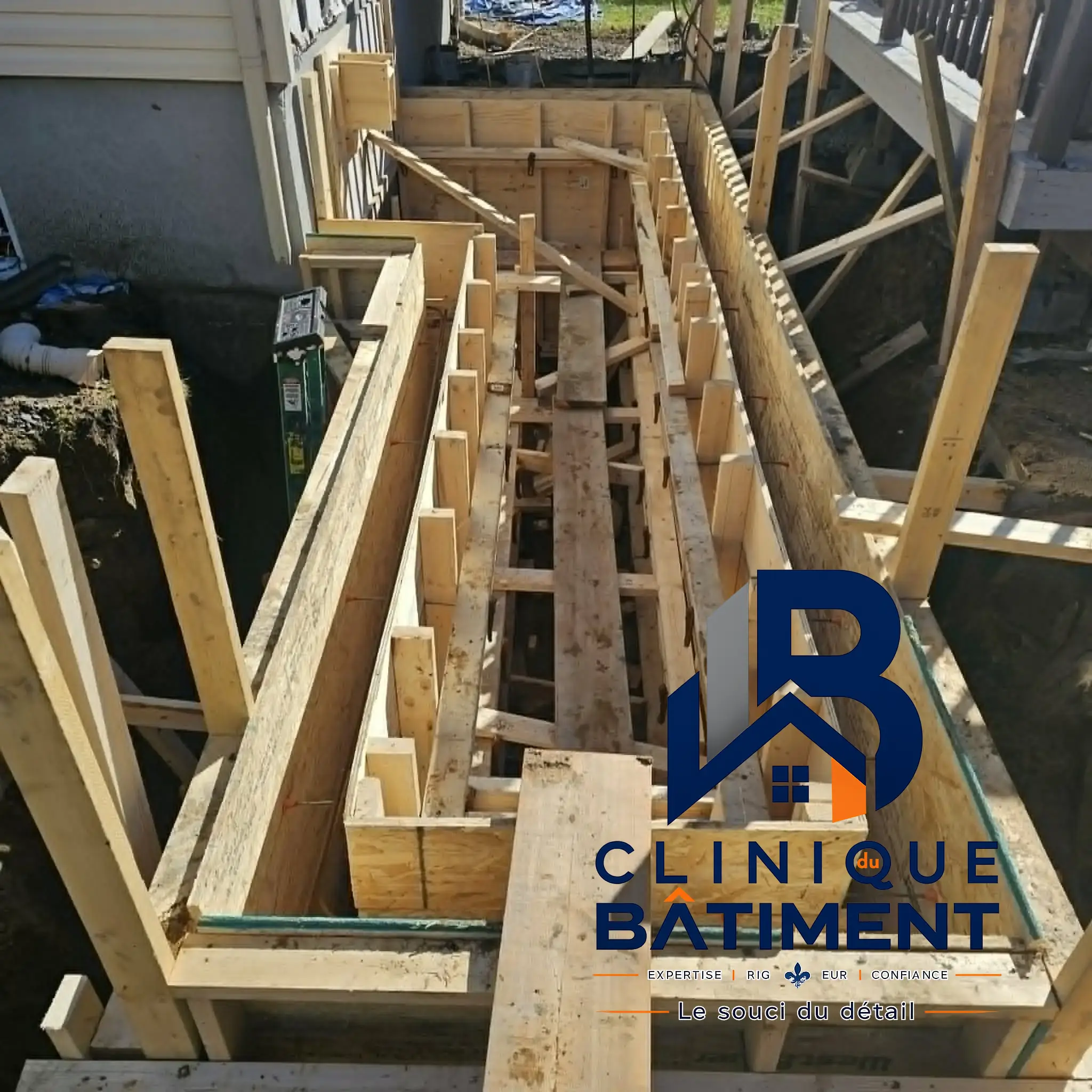 Installation de coffrage en bois pour des fondations en béton le long d'une maison. Chantier de gros œuvre à Longueuil — Clinique du Bâtiment (RBQ 5821-2606-01).