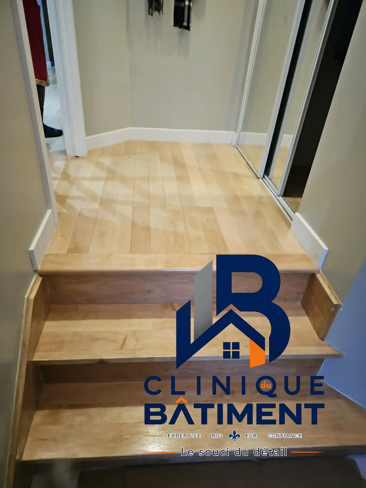 Un escalier en bois mène à un palier avec un revêtement de sol en bois et des murs bien finis. Réalisation de rénovation à Boucherville — Clinique du Bâtiment (RBQ 5821-2606-01).