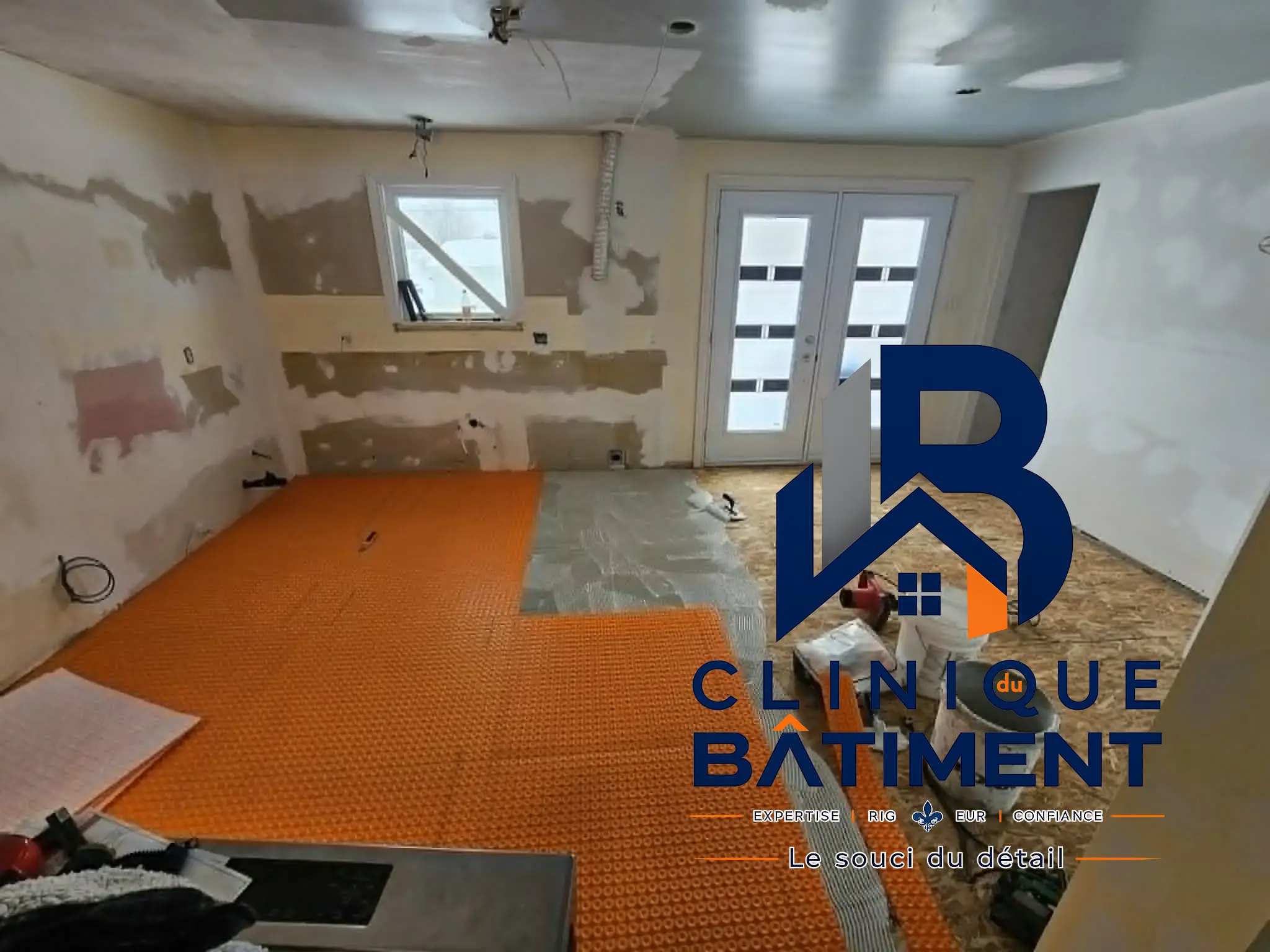 Une pièce en cours de rénovation avec la pose d'une membrane de désolidarisation orange sur le sous-plancher. Chantier de rénovation intérieure à Brossard — Clinique du Bâtiment (RBQ 5821-2606-01).