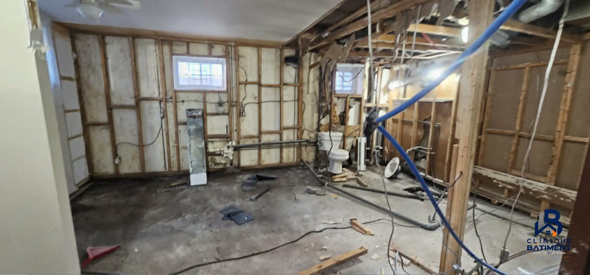 Une cuisine avec des armoires blanches installées mais des tiroirs manquants et des outils de chantier visibles. Chantier de cuisine à Longueuil — Clinique du Bâtiment (RBQ 5821-2606-01).